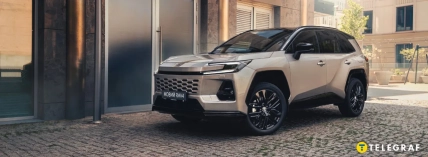 Светлый внедорожник Toyota RAV4 стоит возле современного здания