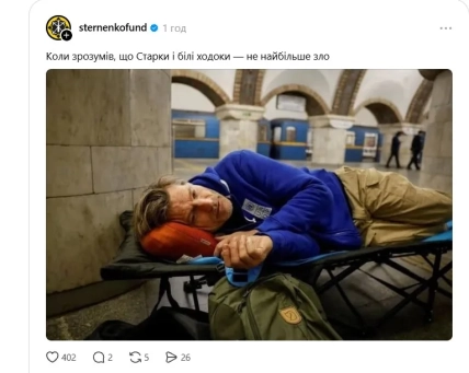 Мужчина в синей кофте лежит на раскладушке у каменной стены на станции метро