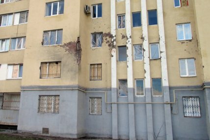 Стіна багатоповерхівки, пошкоджена снарядами