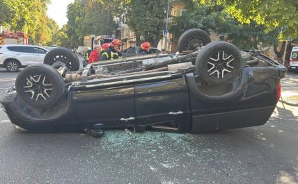 чорна автівка лежить на даху