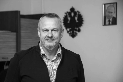 Володимир Леонтьєв на фоні герба РФ та портрета Путіна