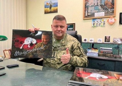 Валерий Залужный показывает календарь с автографом