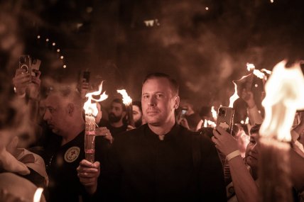 священник тримає свічку з благодатним вогнем