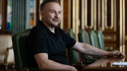 Сергій "Флеш" Бескрестнов у чорній сорочці-поло сидить за столом у приміщенні
