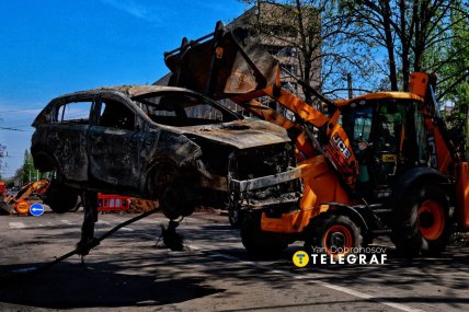 Коммунальные службы убирают сгоревшее авто после удара по Краматорску.