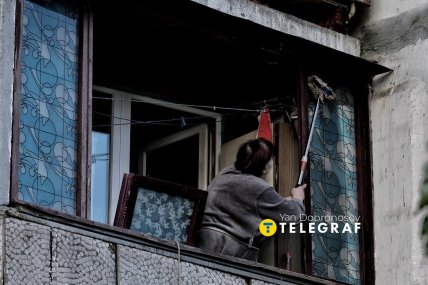 Местная жительница смывает грязь после прилета в Киеве