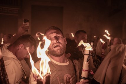 чоловік тримає свічку з благодатним вогнем