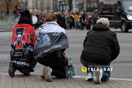Українці стоять на колінах, коли труну несуть вулицею /Ян Доброносов, "Телеграф"