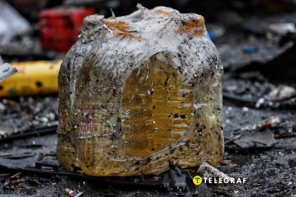 Обплавлений пакунок з пляшками олії серед уламків