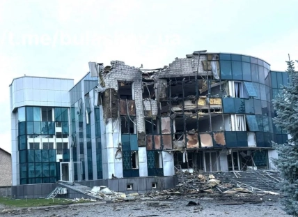 Пошкоджена скляна офісна будівля за металевою огорожею