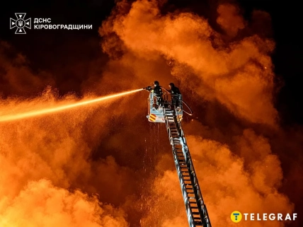 Рятувальники з пожежної автодрабини спрямовують струмінь води на вогонь