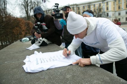 Владислав Гераскевич підписує футболку для забігу