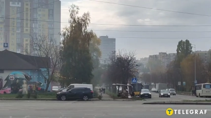 Городская улица с автомобилями, деревьями и многоэтажными домами в дымке