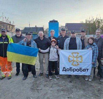 Волонтеры с флагами — украинским и надписью Добробат