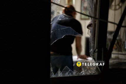 Крізь вибите вікно видно жіночу фігуру