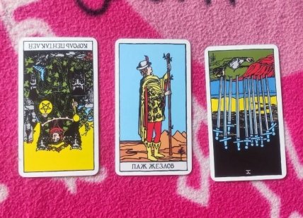 Слева направо — перевернутый Король пентаклей, Паж жезлов и перевернутая Десятка мечей