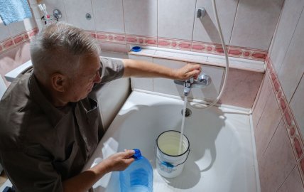 Мужчина набирает воду для повторного использования