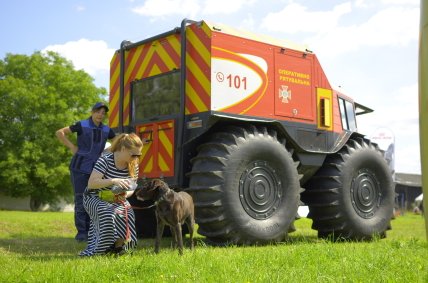 кинолог и хозяйка с собакой рядом со спецавто