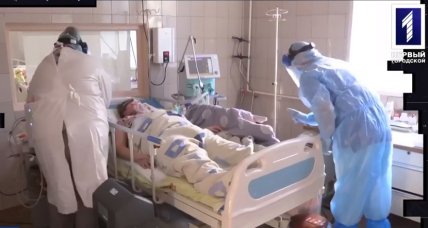 Больная на кровати и двое медиков