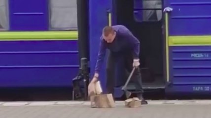 Работник поезда «Укрзалізниці» с топором на перроне взволновал сеть (видео)