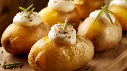 Запечену молоду картоплю подавайте зі сметаною (зображення створено за допомогою ШІ)