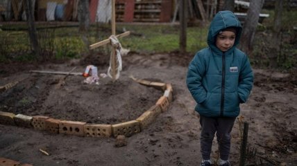 Шестилетний мальчик на могиле мамы, похороненной во дворе дома в Киевской области