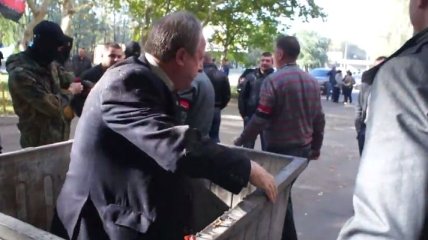В Николаеве чиновника бросили в мусорный бак (Видео)