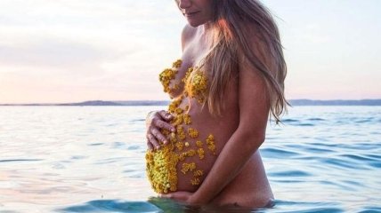Фотограф украшает грудь и живот своей беременной девушки лепестками цветов (Фото) 