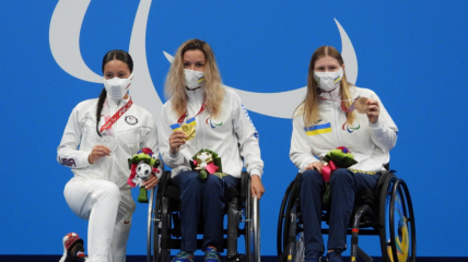 Єлизавета Мерешко (по центру) із золотою медаллю на Паралімпіаді в Токіо, зліва — американка Елізабет Маркс, праворуч — українка Анна Гонтар