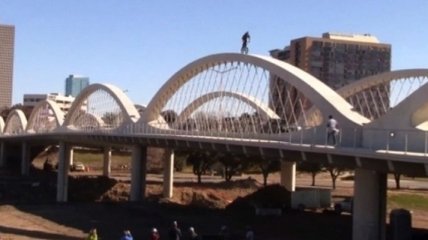 Эктремал проехался по узкой арке высокого моста (Видео)