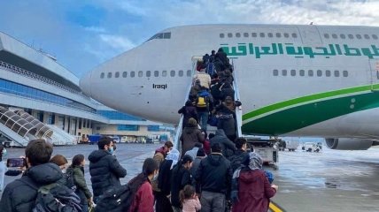 Мигранты садятся в самолет