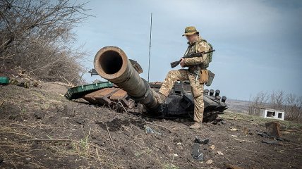 Український військовий біля уламку танка росіян