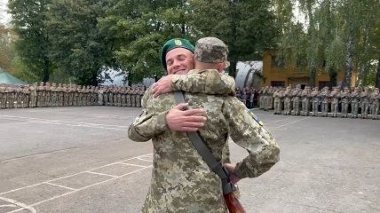 Пограничник Игорь Кучер обнимает сына посреди плаца