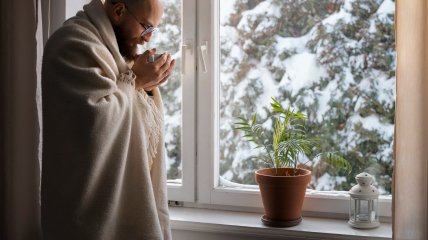 Чоловік мерзне вдома взимку (ілюстративне фото)