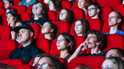 Люди дивляться фільм у кінотеатрі