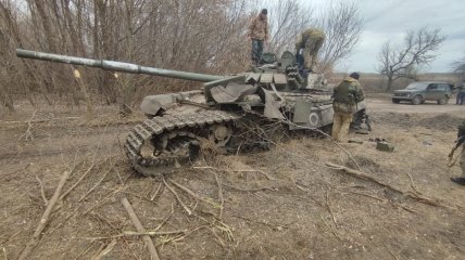 Украинские защитники возле уничтоженного российского танка