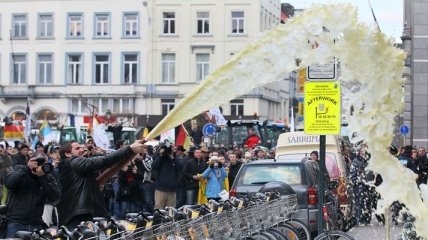 Европейские фермеры в Брюсселе поливают полицию молоком (Фото)
