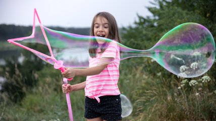 Дівчинка з мильною бульбашкою