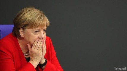 Упала и пошутила: Меркель неудачно поднялась на сцену (Видео)
