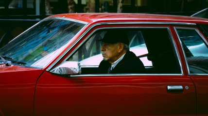 Пожилой мужчина за рулем