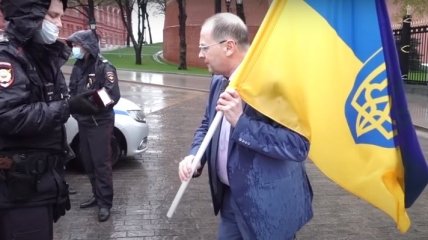 Вырвали из рук и усадили машину: житель Москвы поднял на уши полицию, придя с флагом Украины к Кремлю (видео)