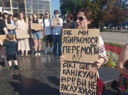 Протестующие с плакатами во время акции в Луцке