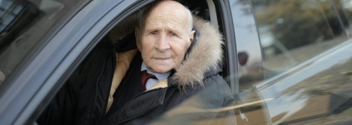 Літній чоловік за кермом