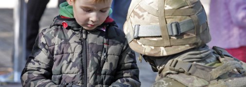 Военный показывает ребенку пистолет