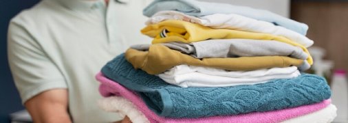 Чоловік тримає одяг та рушники