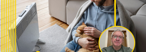 Мужчина с кошкой греется у обогревателя